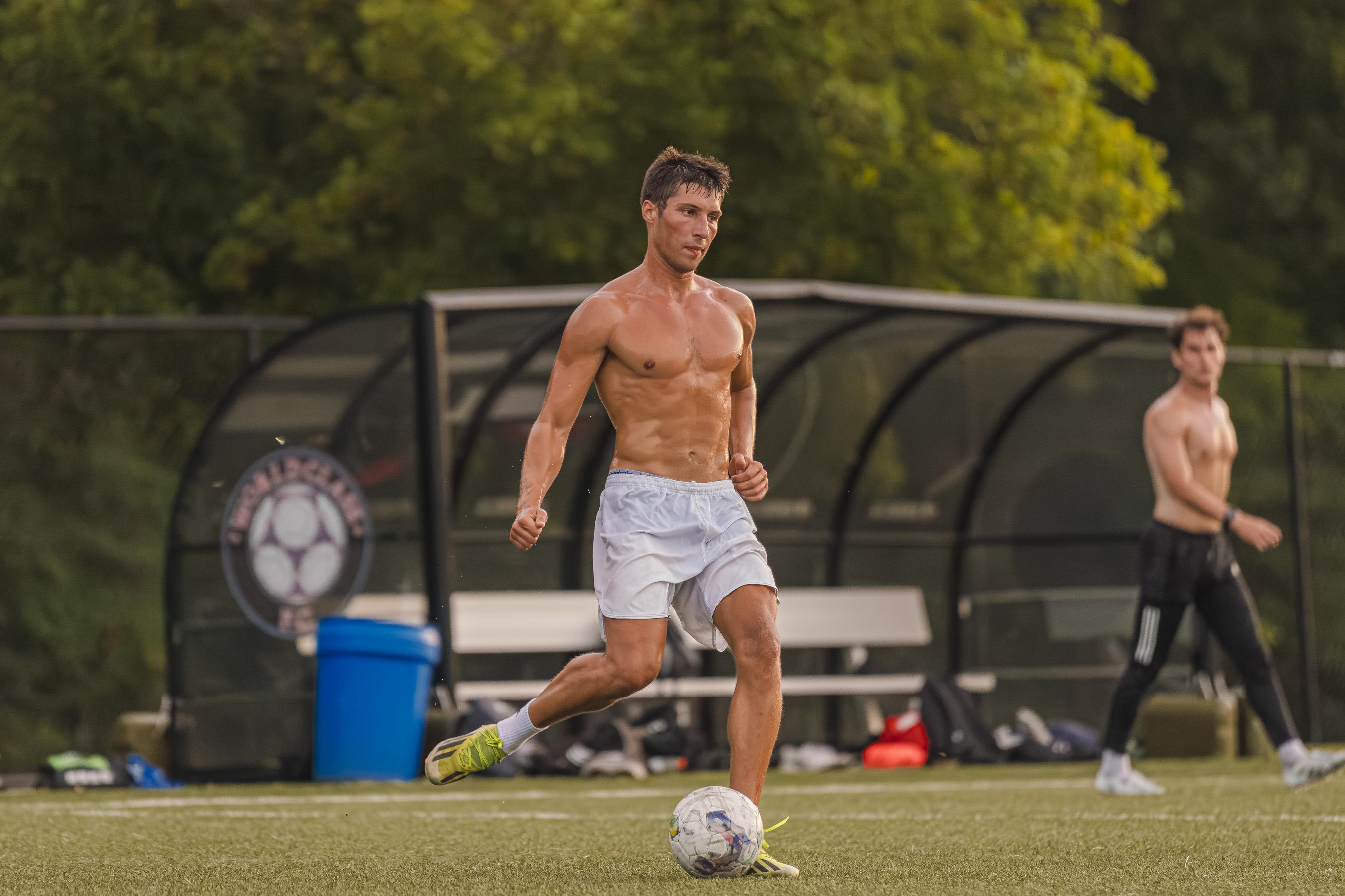 A player dribbling in front of the team bench